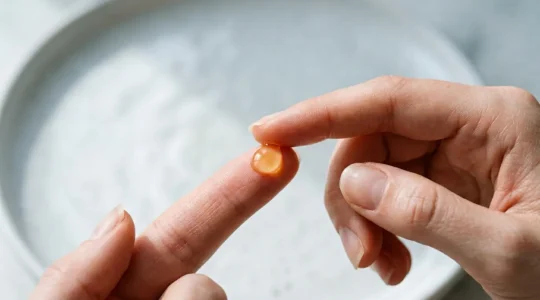 Professional skincare moment showing vitamin C serum application technique with focus on precision and care