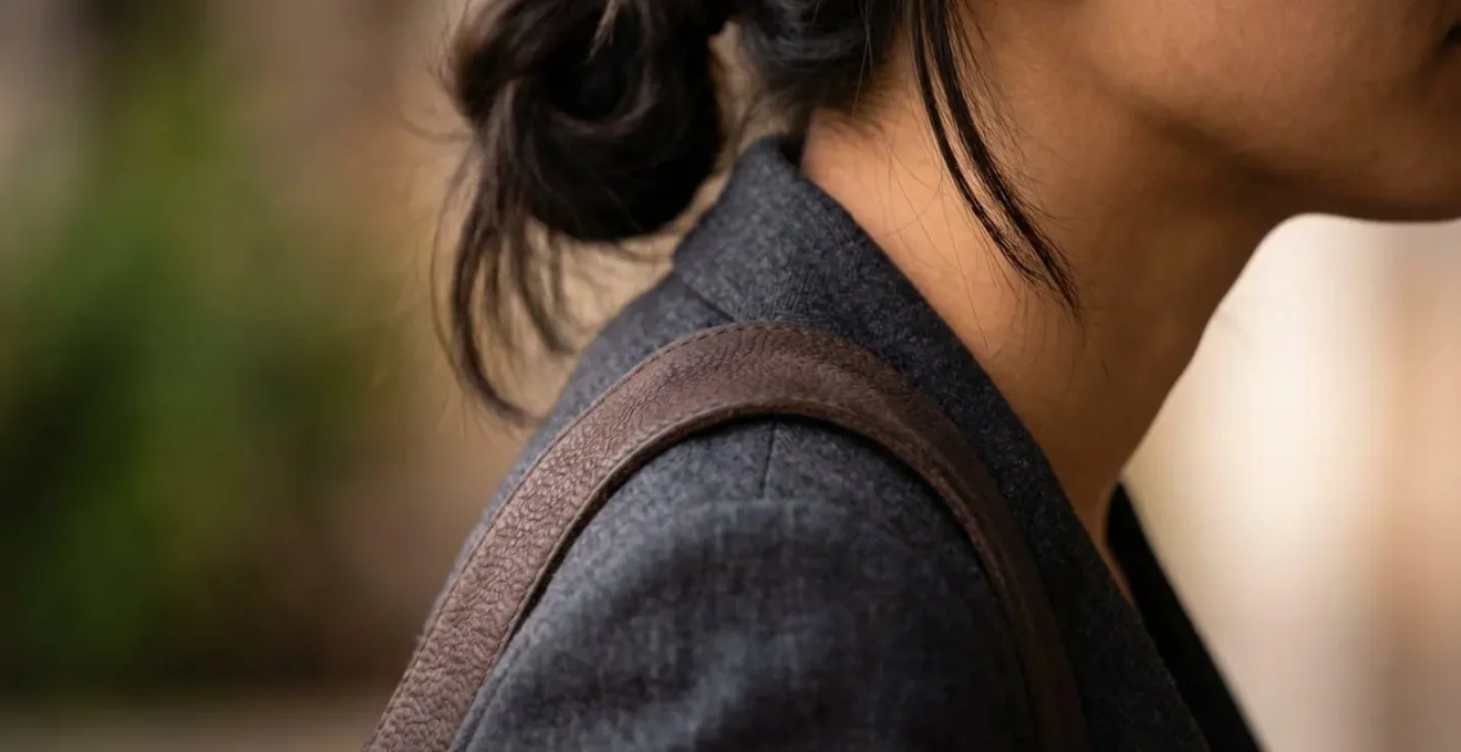 Close-up demonstration of correct shoulder strap positioning on trapezius muscle to prevent tension headaches