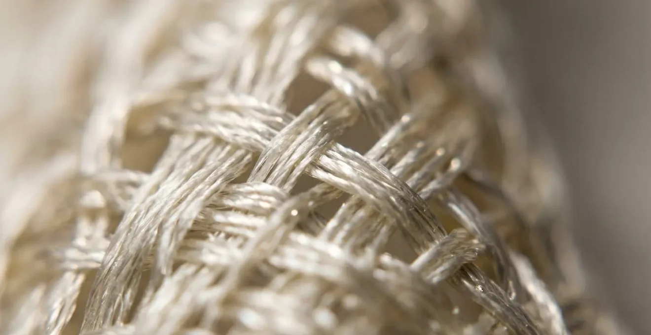 Extreme close-up macro photograph showing abstract textile texture with soft focus highlighting natural fiber structure