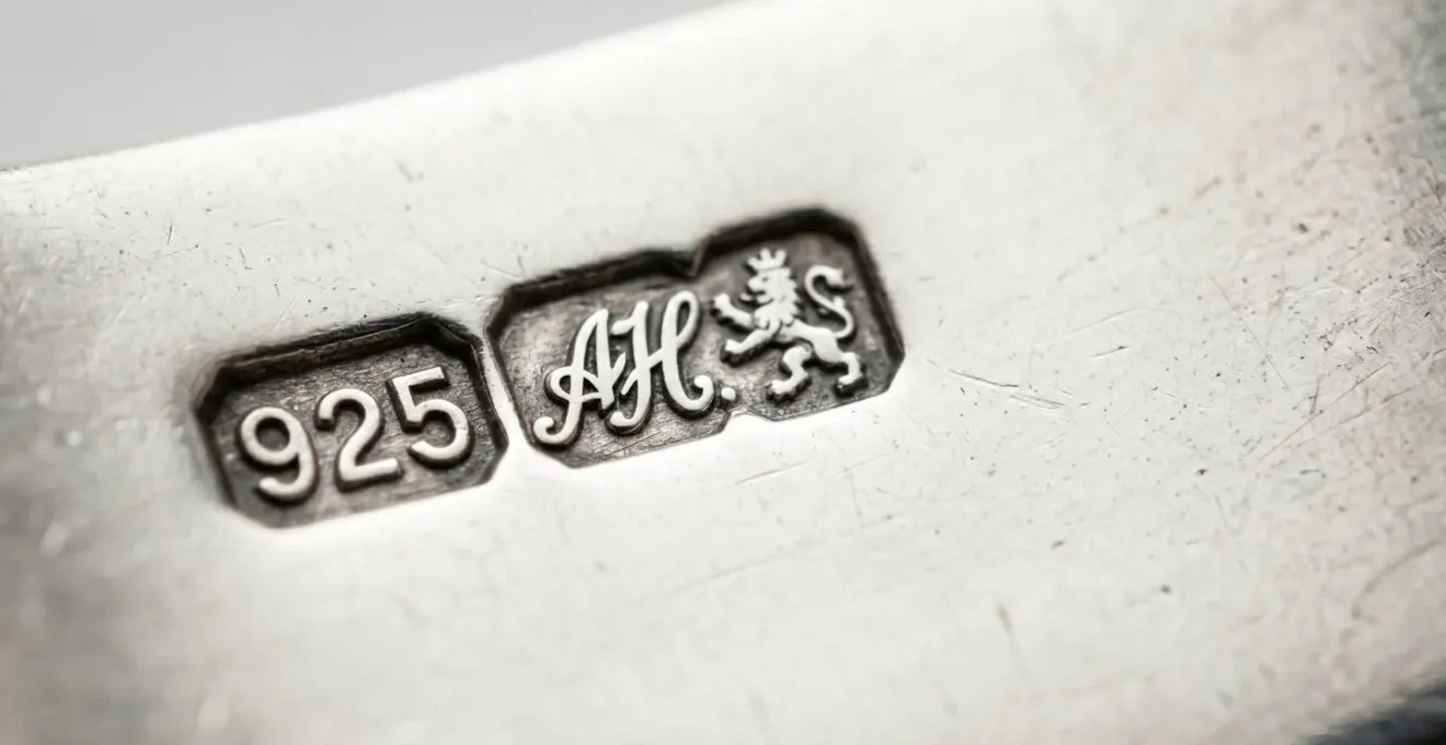 Extreme close-up macro photograph showing crisp sterling silver hallmarks and maker's marks stamped on jewelry surface
